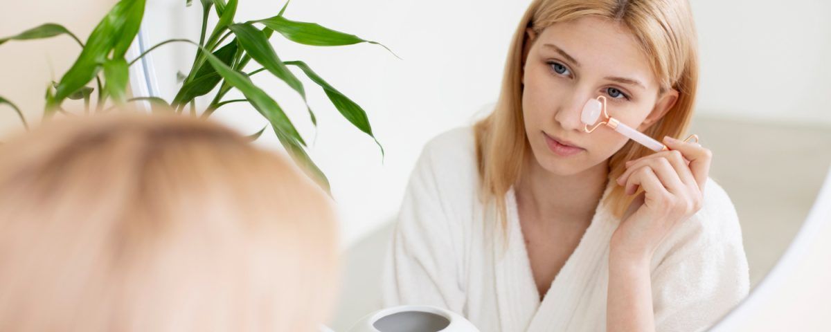 Rutina de îngrijire a tenului efectuată de o femeie în baie